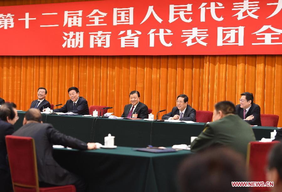 Liu Yunshan (back, C), a member of the Standing Committee of the Political Bureau of the Communist Party of China (CPC) Central Committee and secretary of the Secretariat of the CPC Central Committee, joins a panel discussion of deputies to the 12th National People's Congress (NPC) from central China's Hunan Province during the third session of the 12th NPC in Beijing, capital of China, March 9, 2015. 