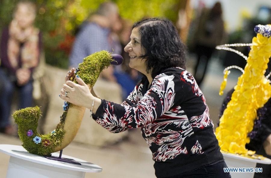 A woman poses with an exhibit as visiting the 2015 Canada Blooms in Toronto, Canada, March 13, 2015.