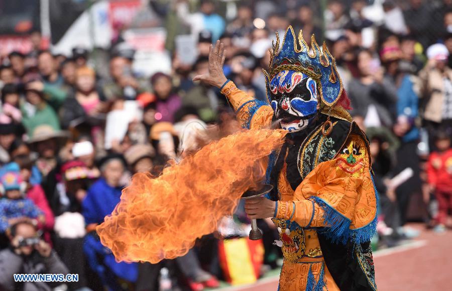 An actor spits fire on a stunt performance of Chuanju Opera in Kangding County, southwest China's Sichuan Province, March 13, 2015. 