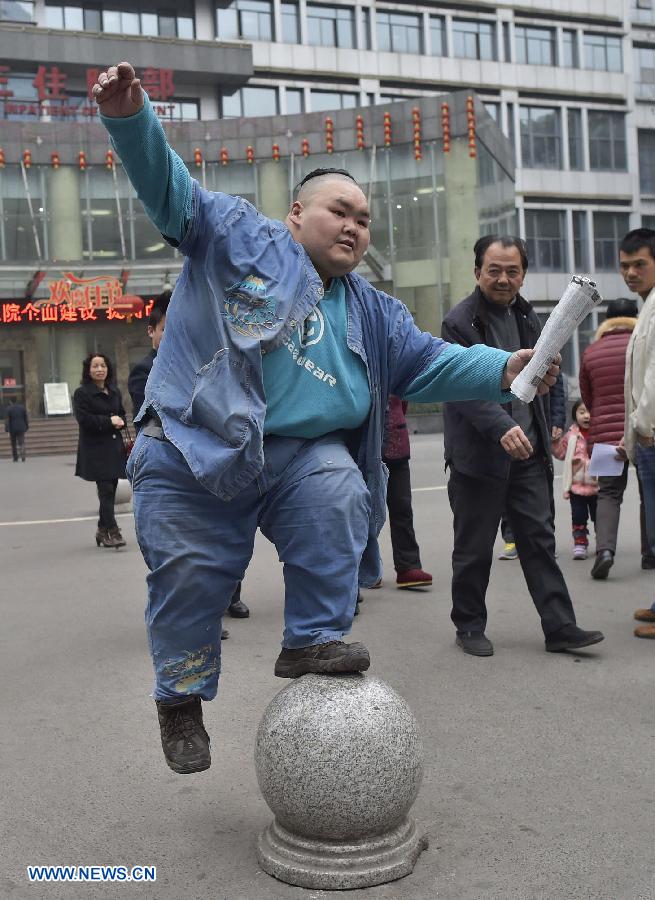 Liang Yong displays his balancing skills as he leaves the hospital where he receives medical treatment in southwest China's Chongqing, March 9, 2015. Liang Yong, who was named as 'the fattest man in China' by China Records Headquarters when he weighed 225 kg in 2007, successfully loses 80 kg after five-year medical treatment.