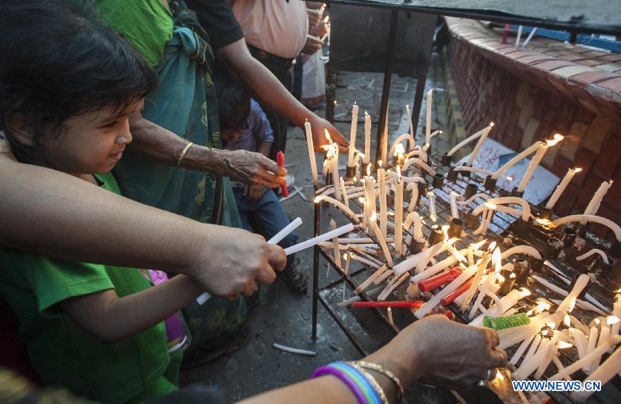 A child participates in a candle light vigil to condemn the recent gangrape of a nun in Kolkata, capital of eastern Indian state West Bengal, March 16, 2015. 