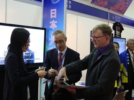 A woman talks to exhibitors at the China International Exhibition Education Tour yesterday. Fewer Chinese children are studying overseas because their parents are “more rational.” (Photo: Shanghai Daily/Zhang Suoqing)