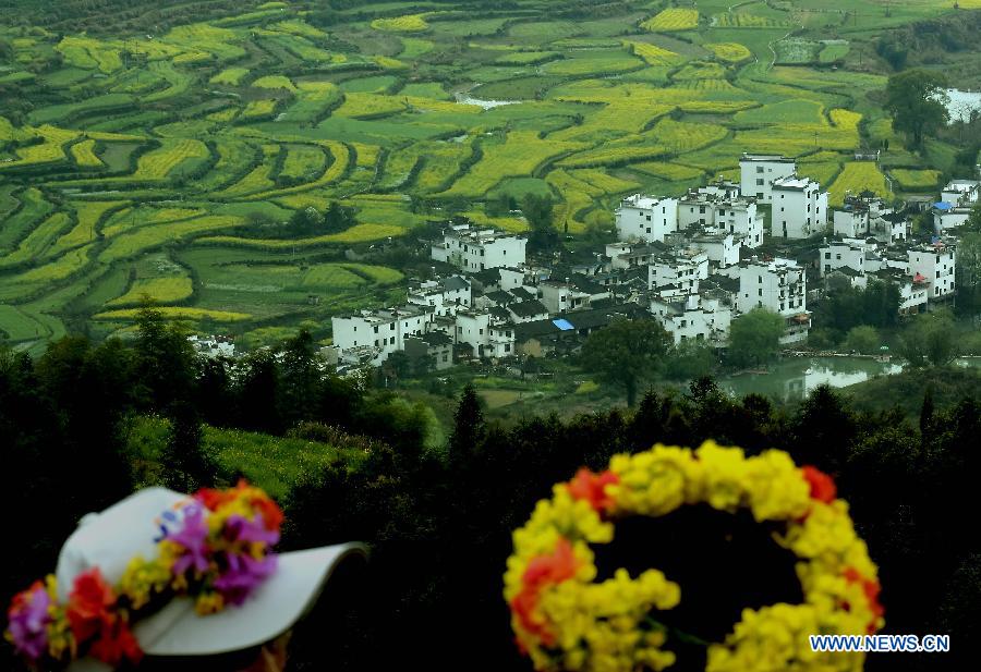 Visitors view cole flower fields in Wuyuan County, east China's Jiangxi Province, March 31, 2015. The cole flower fields make Wuyuan the reputation of the most beautiful village in spring. (Xinhua/Wang Song) 