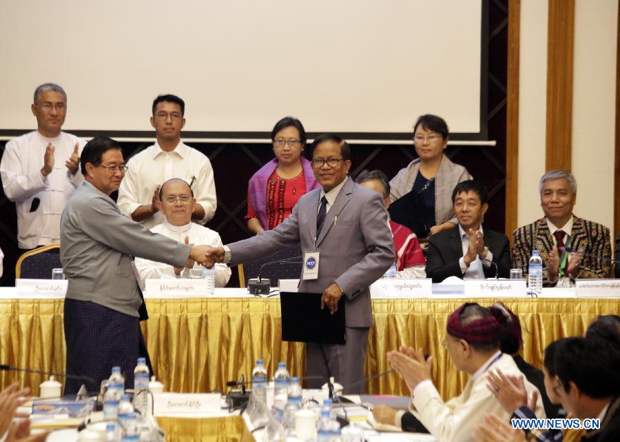 U Aung Min (L), vice chairman of the Myanmar government's Union Peace Making Work Committee (UPWC), shakes hands with U Naing Han Tha (R), leader of the ethnic armed groups' National Ceasefire Coordination Team (NCCT), after exchanging agreement during a signing ceremony of draft of the Nationwide Cease-fire Agreement (NCA) at the Myanmar Peace Center in Yangon, Myanmar, March 31, 2015.