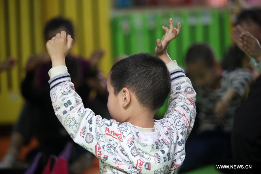 An autistic child receives treatment outside a rent apartment near Huicong Children Rehabilitation and Training Center in Ganzhou, east China's Jiangxi Province, April 1, 2015. April 2 marks the eighth World Autism Awareness Day. (Xinhua/Chen Dichang