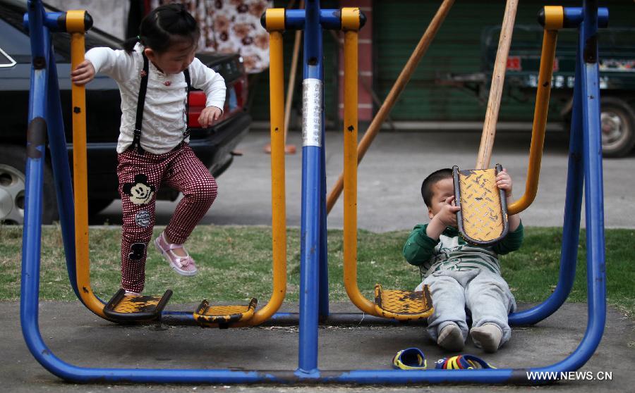 Autistic child Xiaoxiao (R) plays outside Huicong Children Rehabilitation and Training Center in Ganzhou, east China's Jiangxi Province, April 1, 2015. April 2 marks the eighth World Autism Awareness Day. (Xinhua/Chen Dichang)