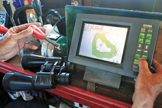 Chen Yiping, captain of fishing boat Qiongqionghai 03889, uses Beidou navigation to guide the vessel to Huangyan Island for fishing. (China Daily/Huang Yiming)