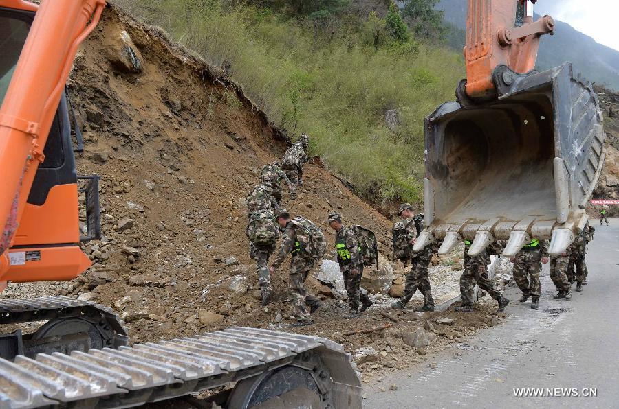 An armed traffic police team was using enginering machinery to repair the highway linking Gyirong Town and Gyirong land port which was blocked by multiple landslides, while 60 members of the team chose to walk to rescue trapped locals affected by Saturday's Nepal earthquake. (Xinhua/Liu Dongjun)