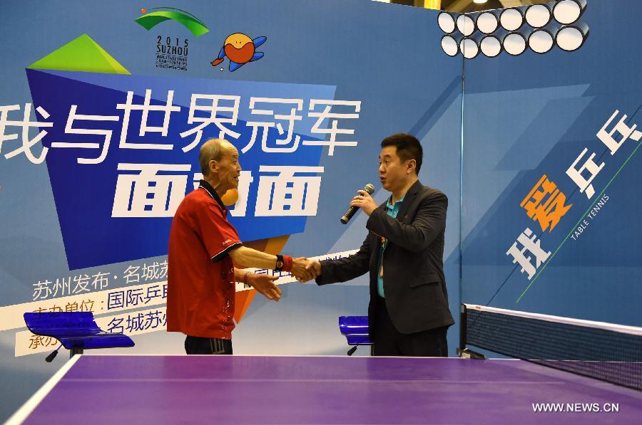 Shi Zhihao, Vice President of ITTF, chats with an elder fan during a promoional movement in Suzhou, city of east China's Jiangsu Province and the host city of the 53rd Table Tennis World Championships. (Xinhua/Song Zhenping) 