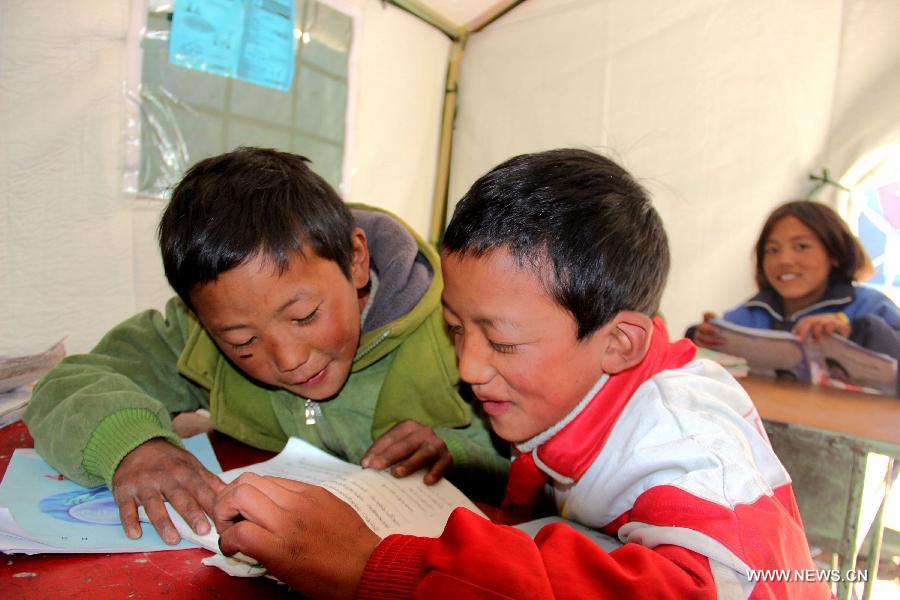 Pupils read books in a tent school in Rongxar Township of Tingri County, southwest China's Tibet Autonomous Region, May 4, 2015. Pupils 