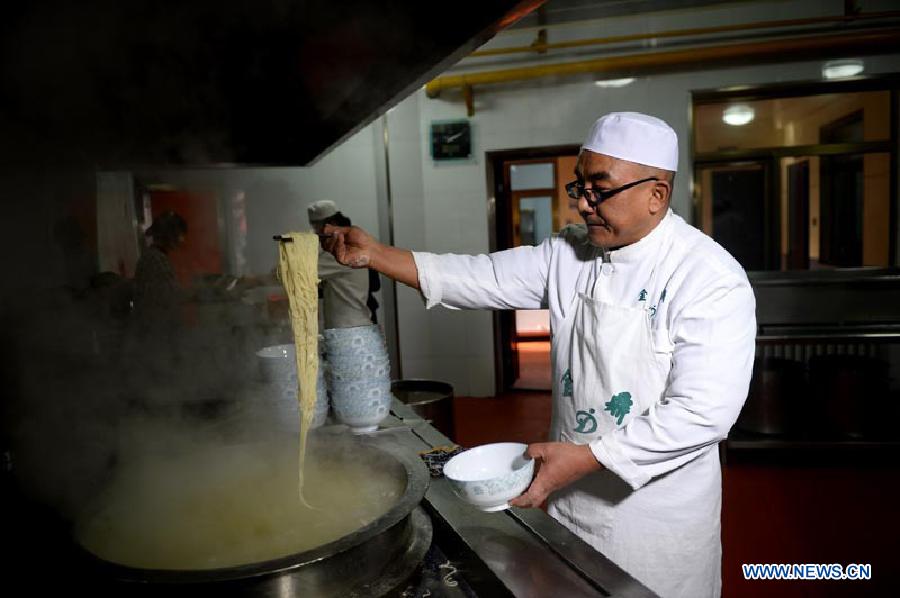 Ma Wenbin, an inheritor of Lanzhou beef lamian, boils noodle at Jinding Beef Lamian Shop in Lanzhou, capital of northwest China's Guansu Province, Jan. 22, 2014. 