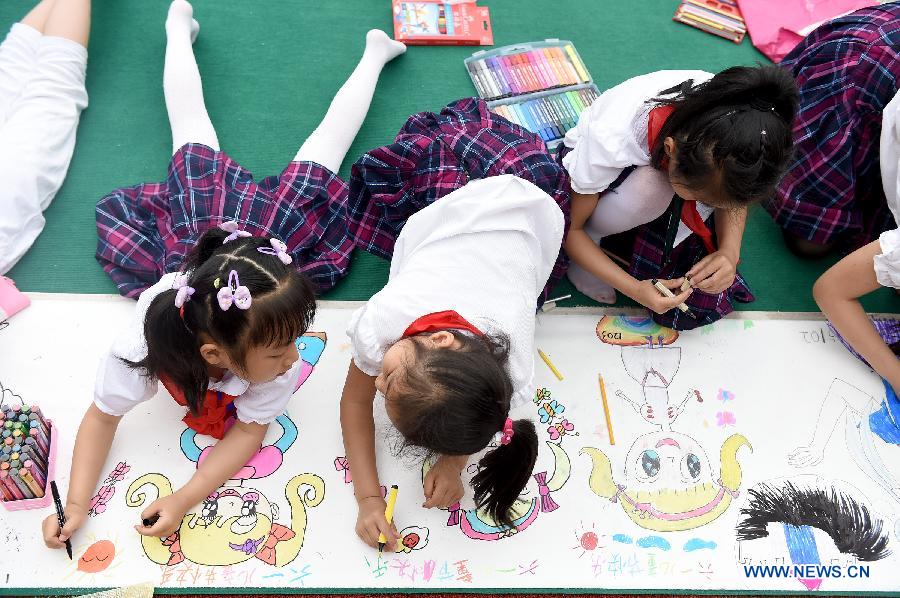 Students draw pictures on a 50-meter-long canvas to welcome the coming Children's Day in Cuitingyuan Primary School in Hefei, east China's Anhui Province, May 28, 2015.