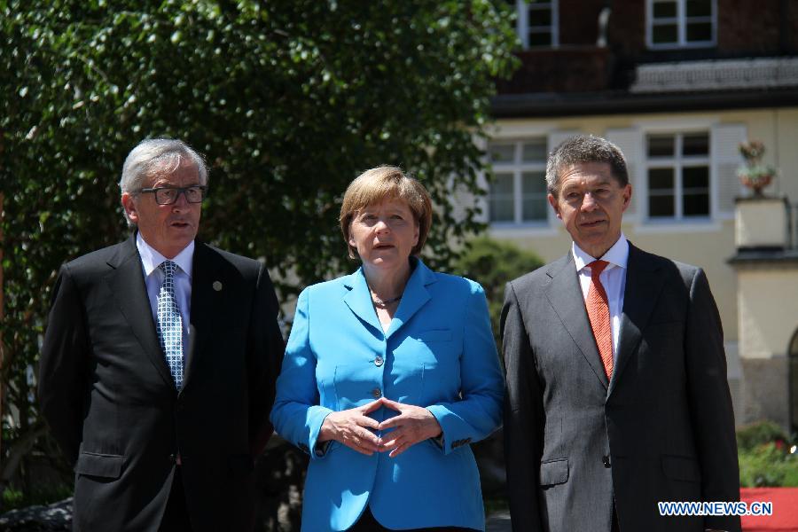 German Chancellor Angela Merkel (C) welcomes President of European Commission Jean-Claude Junker (L) at the Elmau Castle near Garmisch-Partenkirchen, southern Germany, on June 7, 2015. 