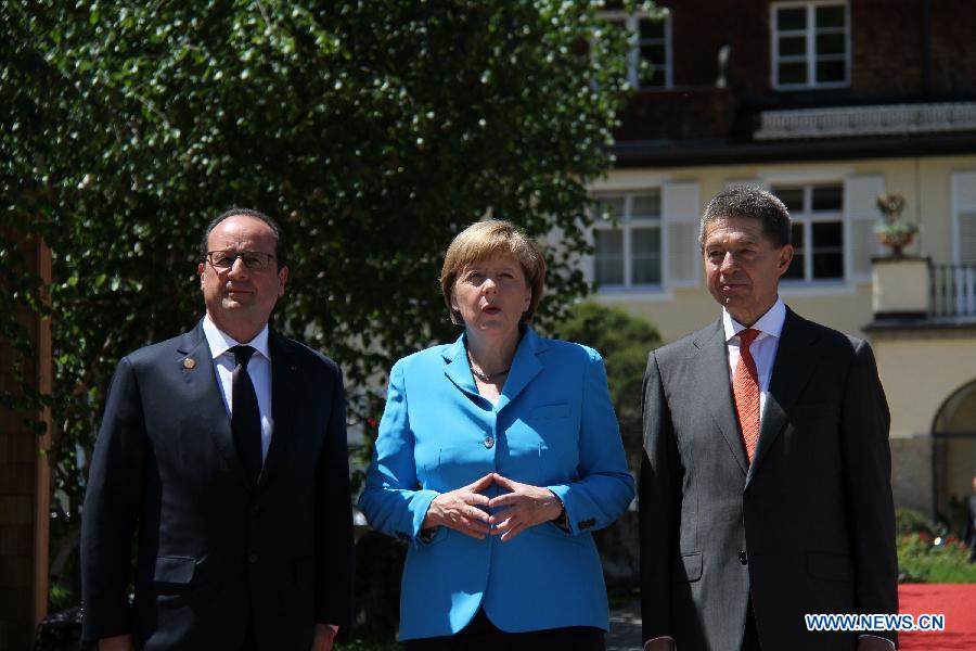 German Chancellor Angela Merkel (C) welcomes French President Francois Hollande (L) at the Elmau Castle near Garmisch-Partenkirchen, southern Germany, on June 7, 2015. 