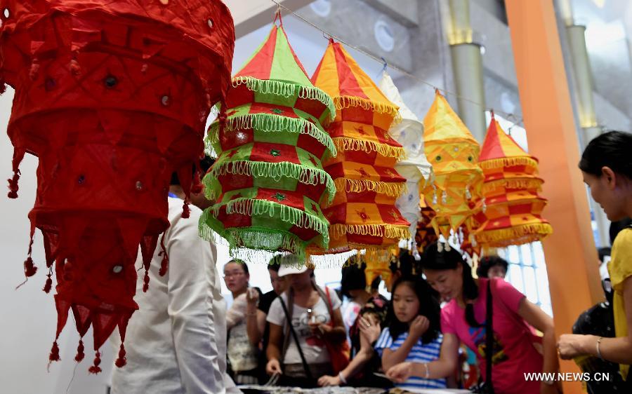 People choose handicrafts from South Asia during the 23rd Kunming Import and Export Fair in Kunming, capital of southwest China's Yunnan Province, June 15, 2015.