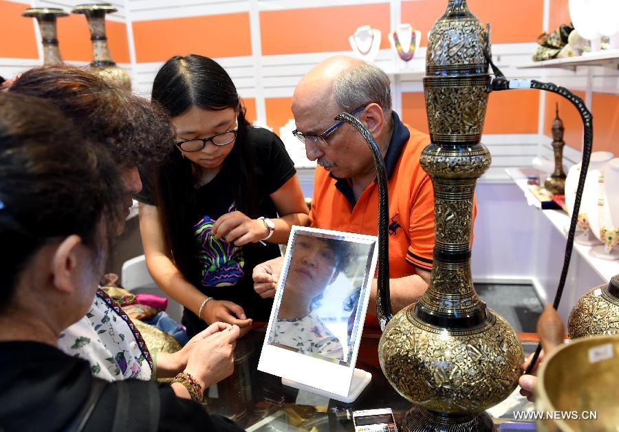 People choose handicrafts from South Asia during the 23rd Kunming Import and Export Fair in Kunming, capital of southwest China's Yunnan Province, June 15, 2015.