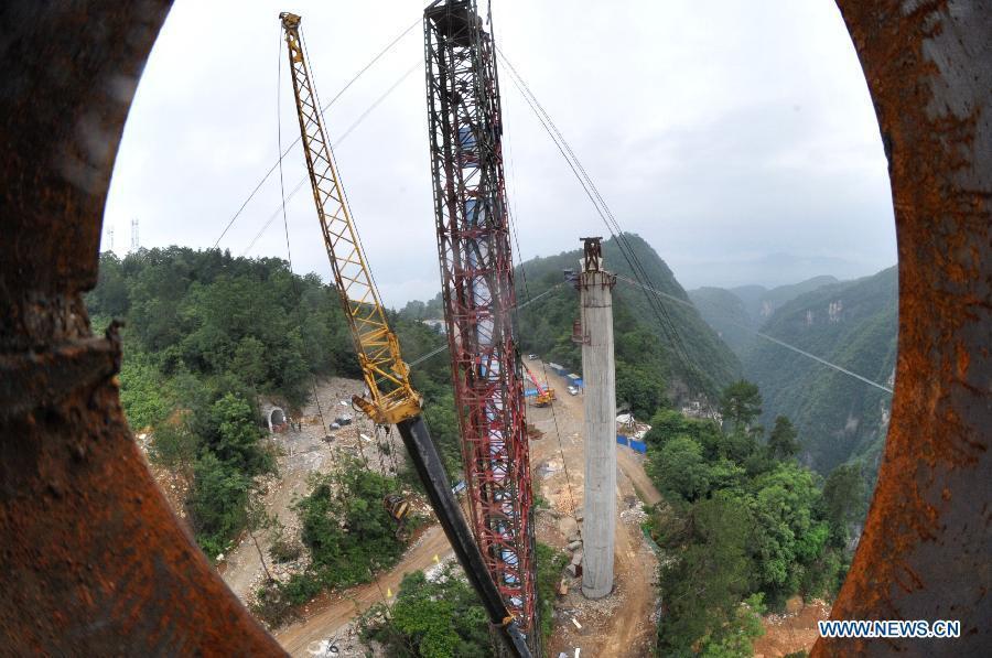 Workers build the vitreous bridge above the grand canyon in Zhangjiajie, central China's Hunan Province, June 15, 2015.