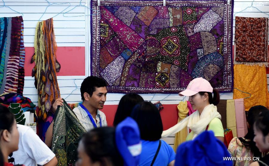 People choose goods from South Asia during the 23rd Kunming Import and Export Fair in Kunming, capital of southwest China's Yunnan Province, June 15, 2015. 