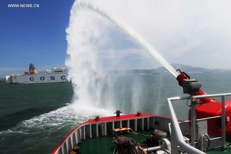 A fireboat sprays water to a passenger vessel during a rescue drill in Xiamen, southeast China's Fujian Province, June 15, 2015. 