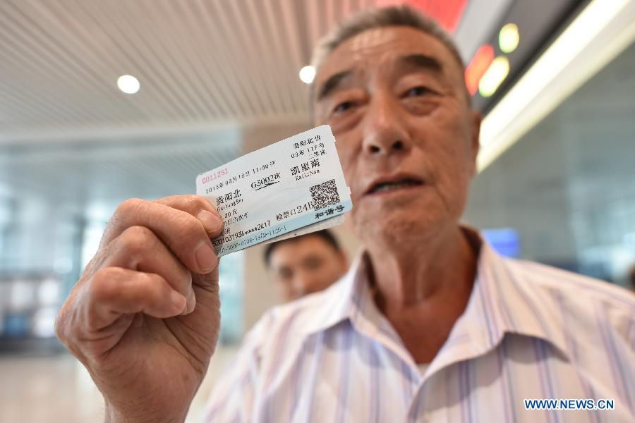 A passenger shows a ticket to take a high-speed train of the Shanghai-Kunming Railway at Guiyang North Railway Station in Guiyang, capital of southwest China's Guizhou Province, June 17, 2015. 