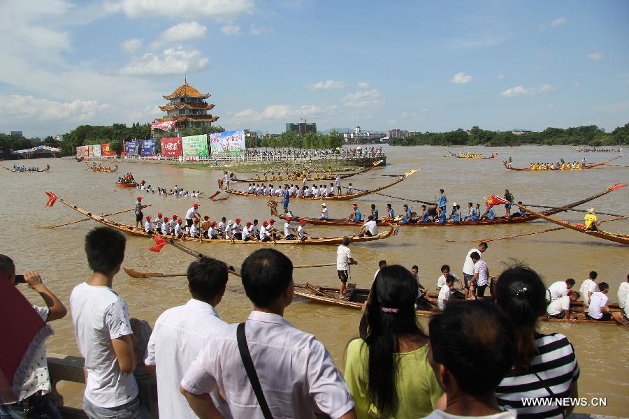 Competitors row dragon boats during a race held on the Xiaoshuihe River to celebrate the coming Dragon Boat Festival in Yongzhou, central China's Hunan Province, June 16, 2015. 