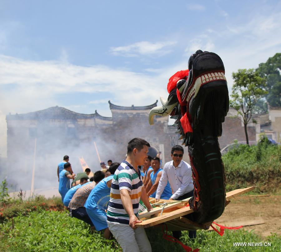 People carry their dragon boat for a race held on the Xiaoshuihe River celebrating the coming Dragon Boat Festival in Yongzhou, central China's Hunan Province, June 16, 2015.