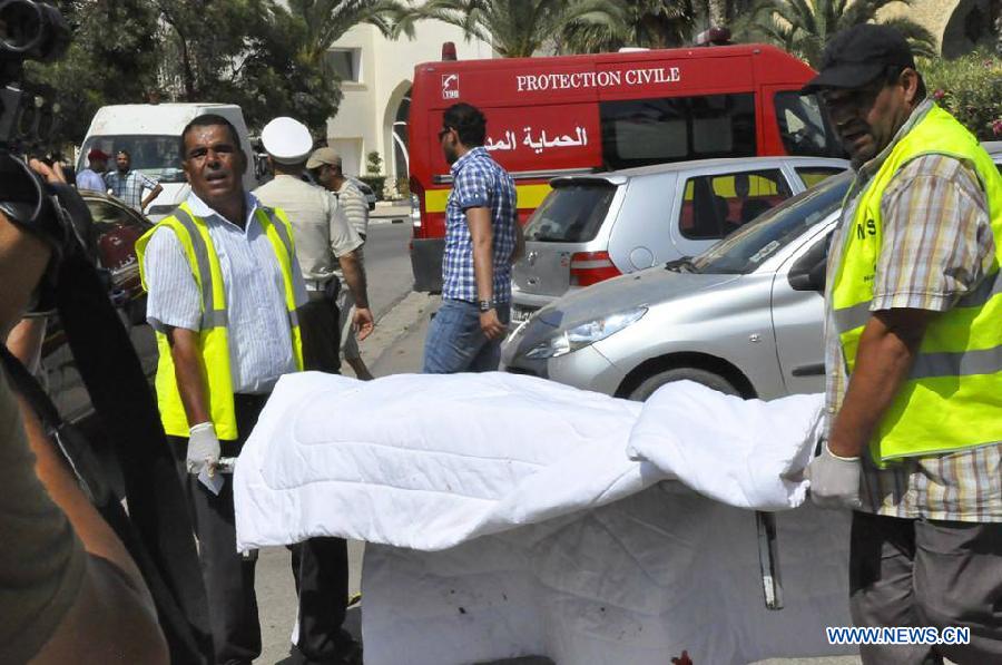 Rescuers carry a victim's body at the attack site in Sousse, Tunisia, June 26, 2015.