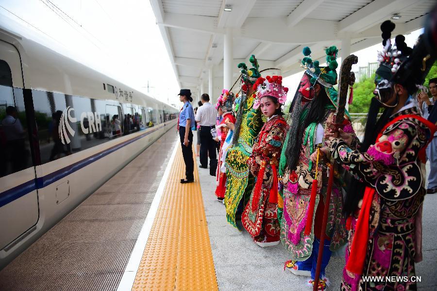 Little actors and actresses of Hui Opera walk to board the G306 high-speed train from Fuzhou to Beijing at the Jixi North Railway Station in Jixi County, east China's Anhui Province, June 28, 2015.