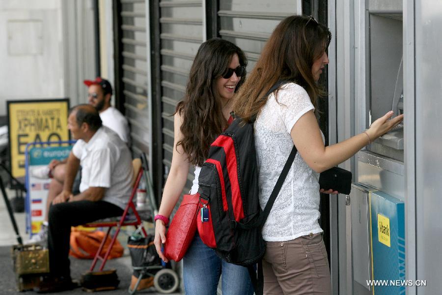 People line up at an ATM outside a National bank branch in Athens, June 29, 2015. 