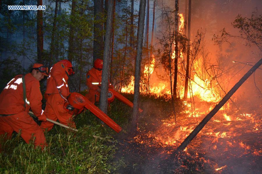 Firefighters put out a forest fire in the northern part of the Great Khingan Mountains in north China's Inner Mongolia Autonomous Region, July 6, 2015. 