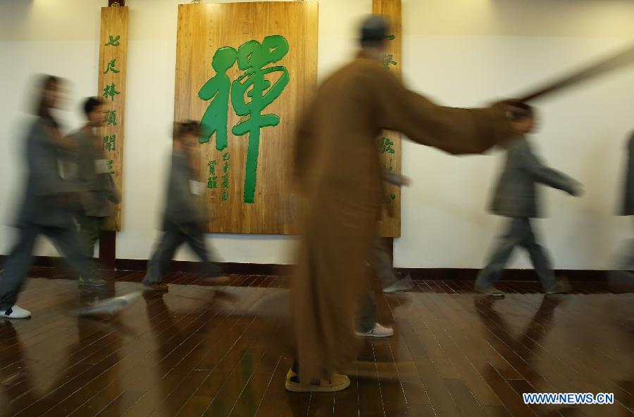 A master teaches citizens in a Zen class in the Yufo Temple, or Jade Buddha Temple, in Shanghai, east China, July 8, 2015.