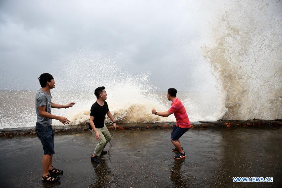 Tourists dodge waves in Huagang Village of Dongtou County, Wenzhou, east China's Zhejiang Province, July 10, 2015.