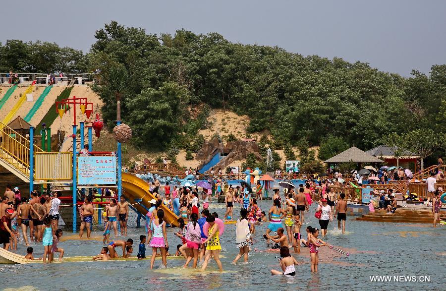 People have fun at a water park in Qinhuangdao, a popular seaside resort in north China's Hebei Province, July 14, 2015. 