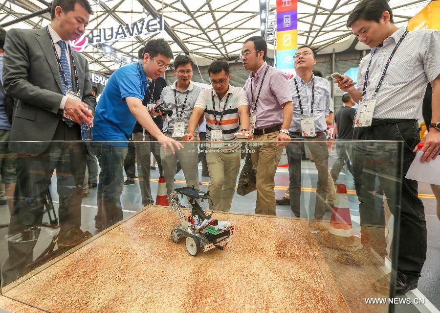 Spectators watch a robot at Mobile World Congress (MWC) with the theme of Mobile Infinity in Shanghai, east China, July 15, 2015. 