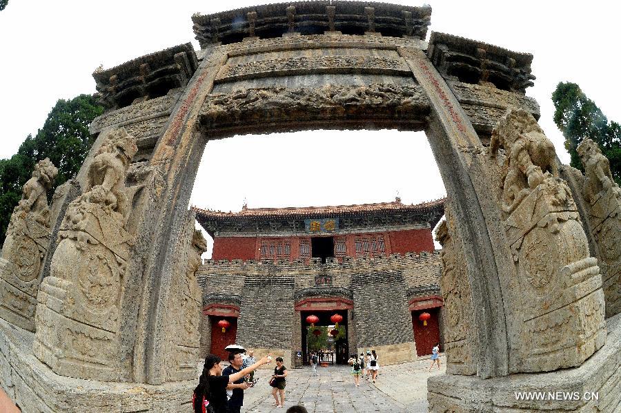 Tourists appreciate an archway in front of Dai Temple (Temple of Mount Tai) at the foot of Mount Tai in Tai'an, east China's Shandong Province, July 17, 2015. 