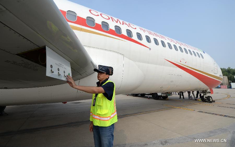 A ground crew member checks the ARJ21-700 jet after a demonstration flight in Xi'an, capital city of northwest China's Shaanxi Province, July 17, 2015.