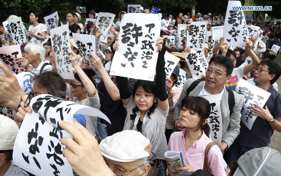 People hold placards reading 'Abe politics is unforgivable' during a rally in front of the parliament building in Tokyo, Japan, July 18, 2015. About five thousand people took part in the demonstration.