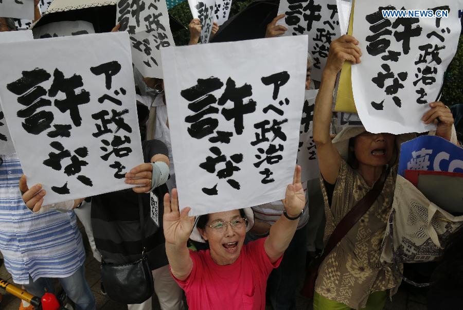 People hold placards reading 'Abe politics is unforgivable' during a rally in front of the parliament building in Tokyo, Japan, July 18, 2015. About five thousand people took part in the demonstration.