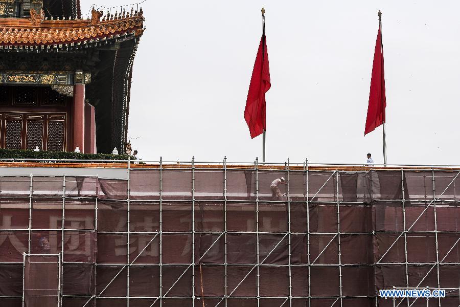 Workers paint walls of Tian'anmen Rostrum in Beijing, capital of China, July 23, 2015. 