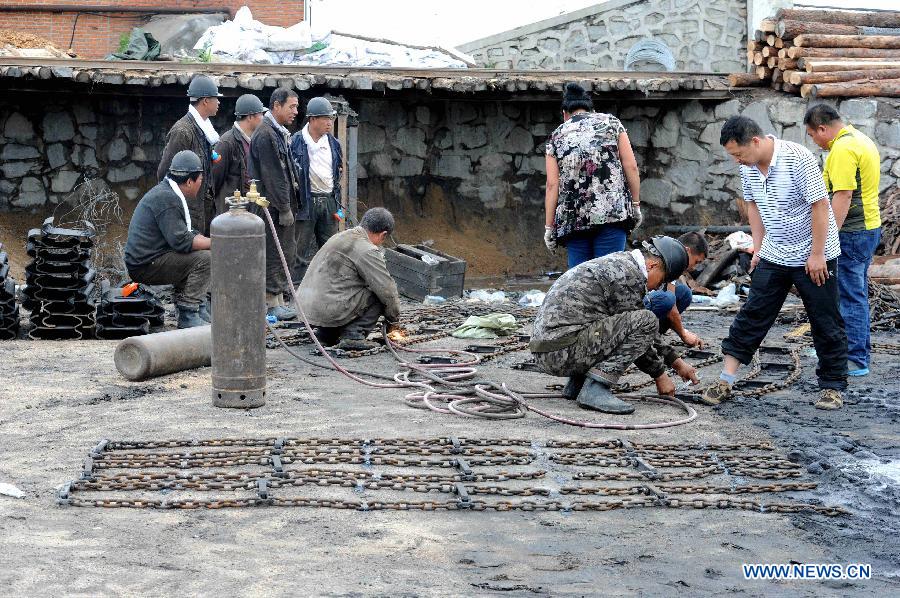 Rescuers weld rescue equipments at Xuxiang Colliery in Hegang City, northeast China's Heilongjiang Province, July 24, 2015. 