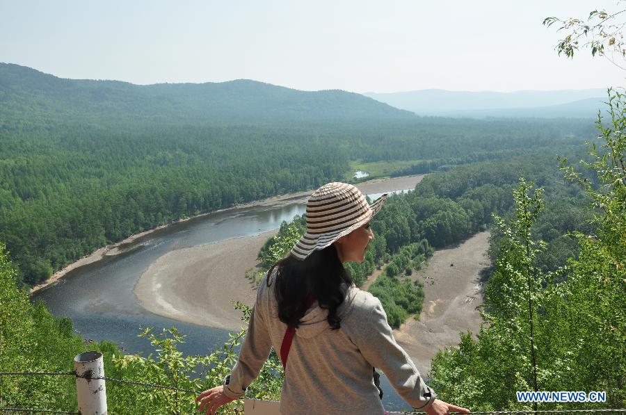 A tourist sightsees in Mangui Township, Genhe County, north China's Inner Mongolia Autonomous Region, July 24, 2015.