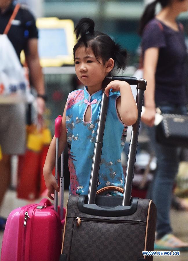 A girl waits for boarding train at Beijing South Railway Station in Beijing, July 24, 2015.