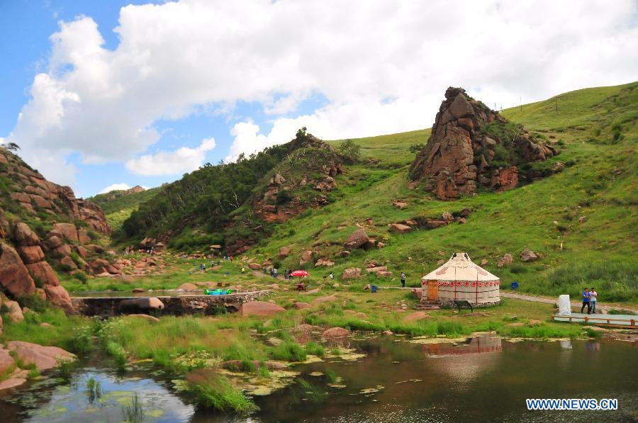 Tourists enjoy the scenery of the grassland near Ulanqab City, north China's Inner Mongolia Autonomous Region, July 24, 2015. 