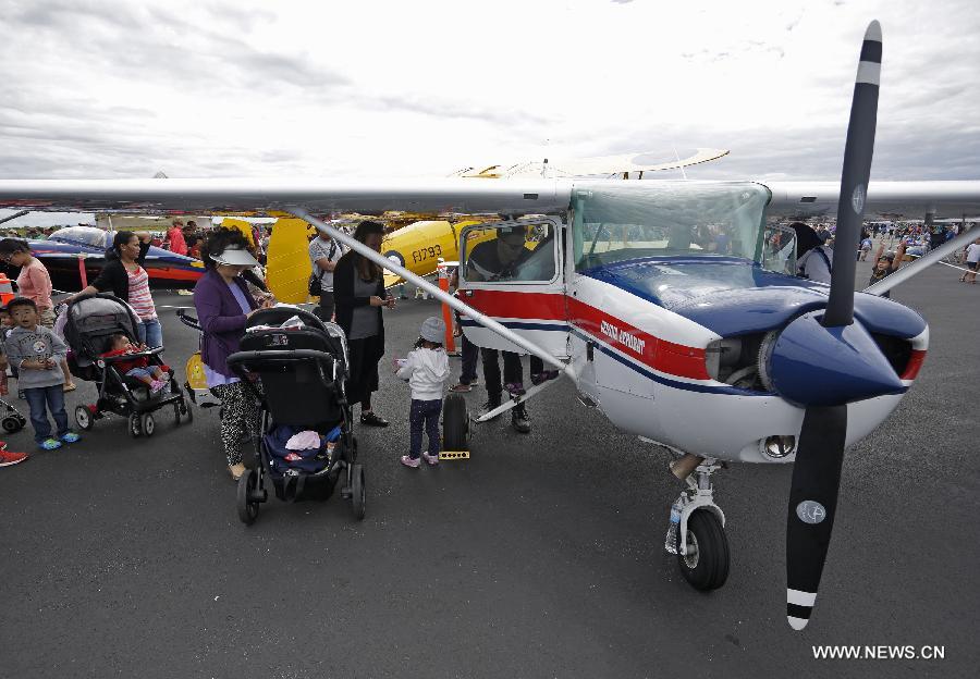 Visitors line up to view the interior of a single engine aircraft at the Boundary Bay air show in Delta, Canada, July 25, 2015. 