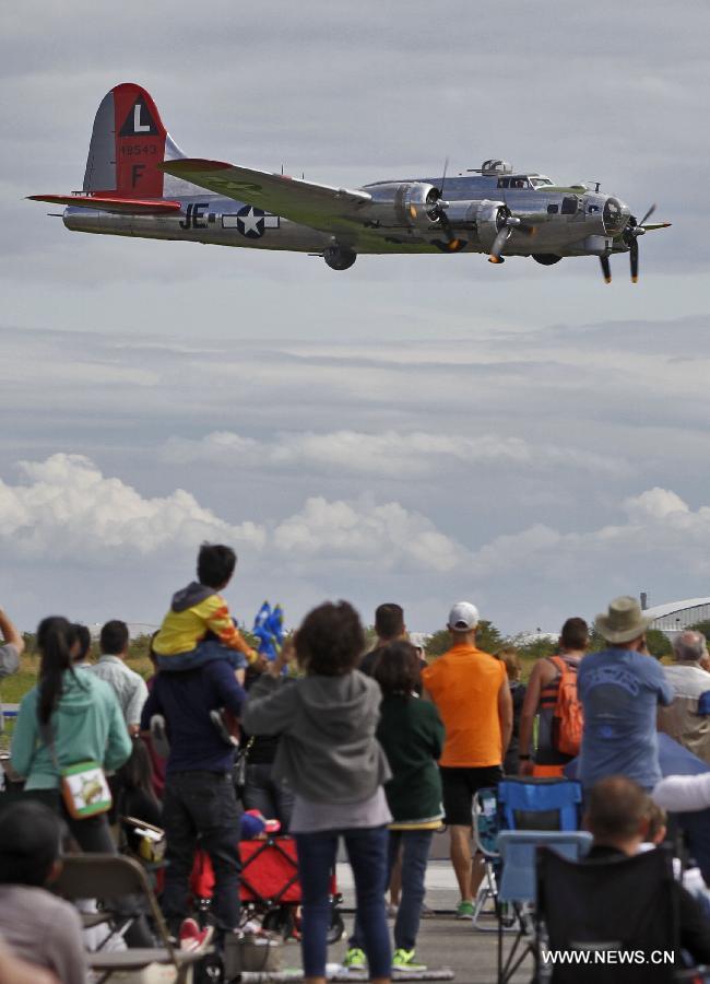 Crowds watch a Boeing B-17 heavy bomber aircraft performs a flight demonstration at the Boundary Bay air show in Delta, Canada, July 25, 2015. 