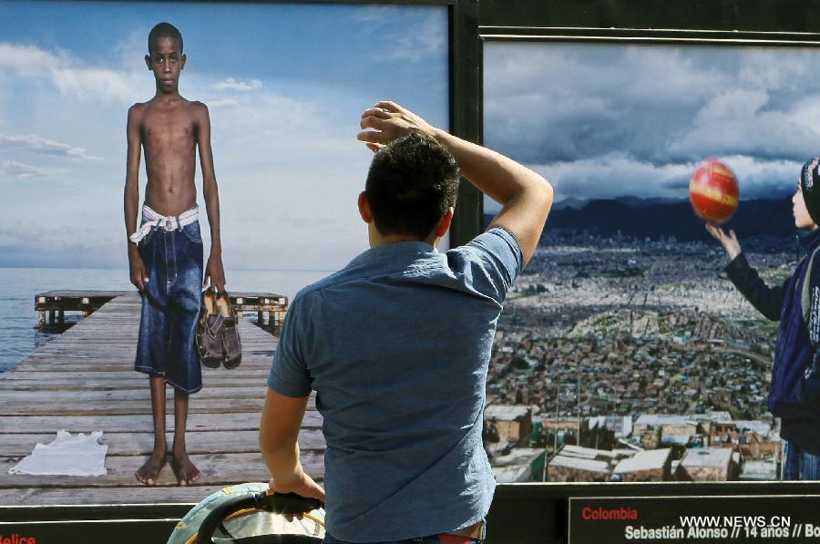 A man watches the photographic show 'Infancia' by Spanish photographer Isabel Munoz, in the Heroic Youth Road of the Forest of Chapultepec, in Mexico City, capital of Mexico, on July 26, 2015. 