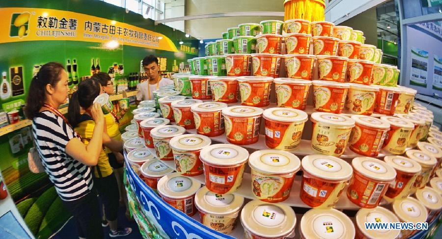 Exhibitors display potatoes during the China Potato Expo in Yanqing County of Beijing, capital of China, July 28, 2015. A total of 196 enterprises of potato industry from 11 countries and regions took part in the two-day expo where food, pesticides, machines and seedlings for potato planting are on display. (Xinhua/Li Xin) 