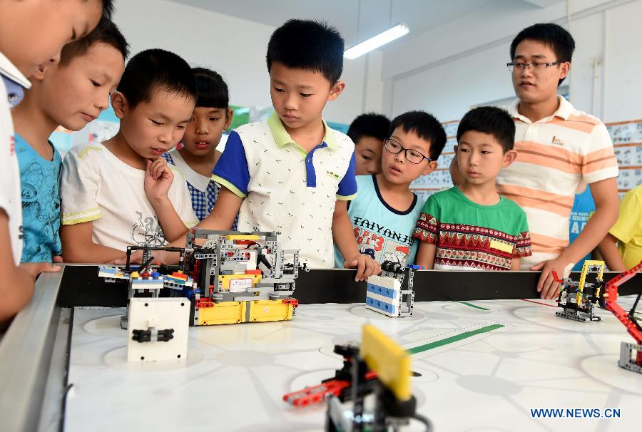 Members of an interest group at Furong primary school test a robot during a summer camp class in Hefei, capital of east China's Anhui Province, July 30, 2015. A robot class held in the Furong primary school of Hefei attracted many students during the summer vacation. (Xinhua/Liu Junxi) 