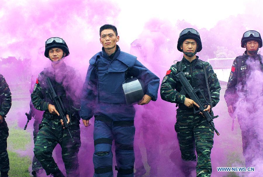 Xie Liuxiang, an Explosive Ordance Disposal(EDO) police, walks out of the training with his comrades after their training in east China's Shanghai Municipality, July 30, 2015. EDO police of Shanghai armed police unit continued their training as the heat wave scorched Shanghai. (Xinhua/Chen Fei) 