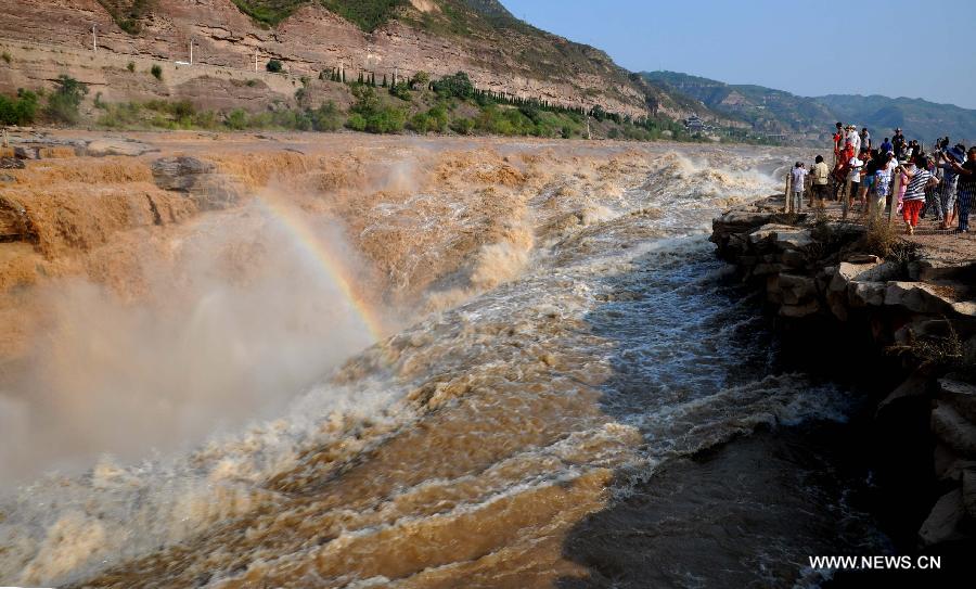 People visit the Hukou waterfall of the Yellow River in Jixian County, north China's Shanxi Province, July 30, 2015. Influenced by heavy rainfalls in the upstream, the half clean and half turbid waterfall became a splendid scenery for sightseeing. (Xinhua/Lyu Guiming) 